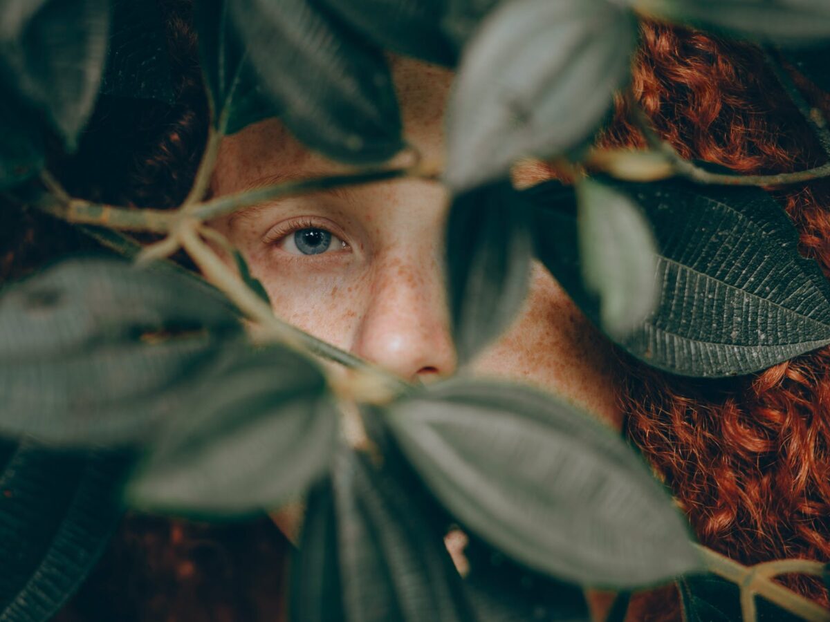 close up photo of person behind leaves